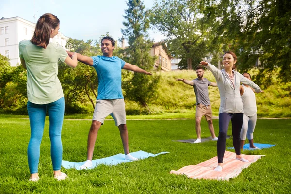 Skupina lidí dělá jógu s instruktorem v parku — Stock fotografie