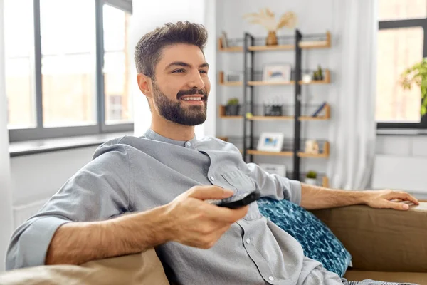 Homem feliz com controle remoto assistindo tv em casa — Fotografia de Stock