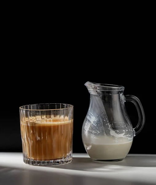 Caffè in vetro e brocca di latte o panna in tavola — Foto Stock