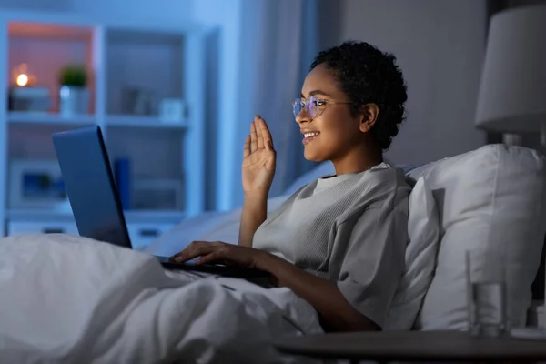 Frau telefoniert nachts mit Laptop im Bett — Stockfoto