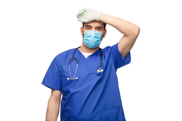 Vermoeide mannelijke arts in blauw uniform, masker en handschoenen — Stockfoto