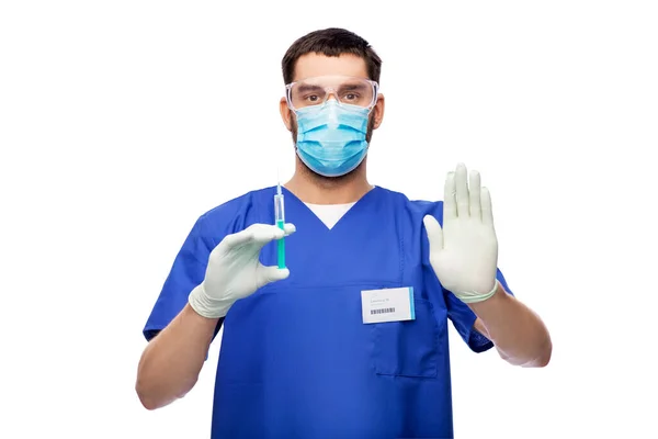 마스크를 쓰고 주사기 장갑을 끼고 있는 남자 의사 — 스톡 사진