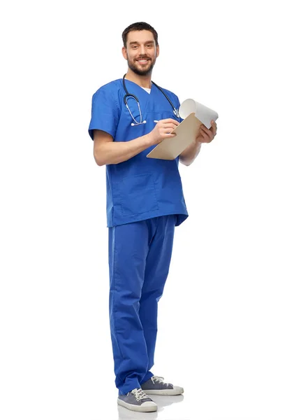 Male doctor writing medical report on clipboard — Stock Photo, Image