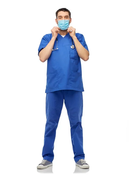 파란색 제복을 입고 마스크를 쓴 남자 의사 — 스톡 사진