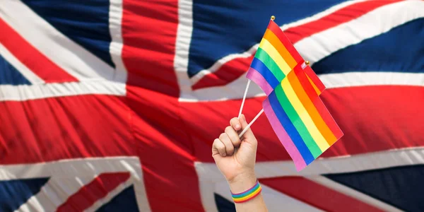 Mano con orgullo gay arco iris banderas y pulsera —  Fotos de Stock