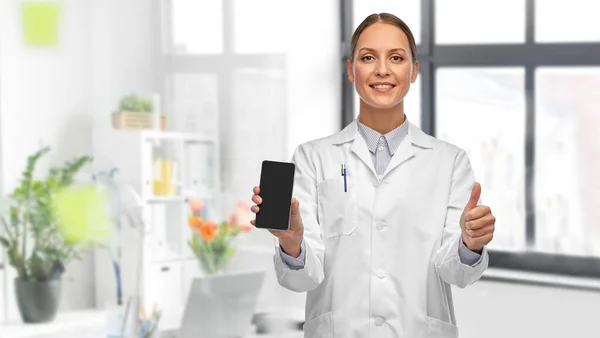 Doctora con smartphone mostrando los pulgares hacia arriba —  Fotos de Stock