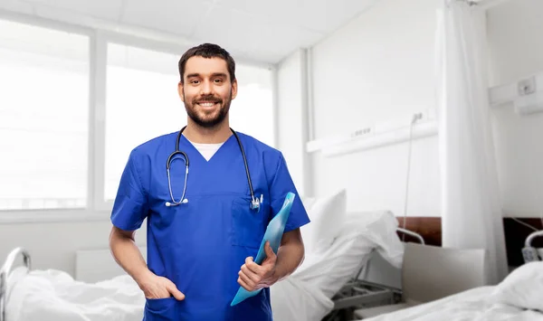 Médico sonriente o enfermero masculino con carpeta —  Fotos de Stock