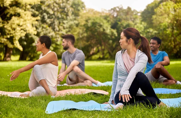 Group of people doing yoga at summer park — Stock Photo, Image