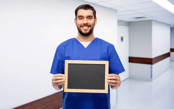 Glücklich lächelnder Arzt oder Krankenpfleger mit Kreidetafel — Stockfoto