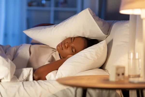 Wütende Afrikanerin liegt im Bett und schließt die Ohren — Stockfoto