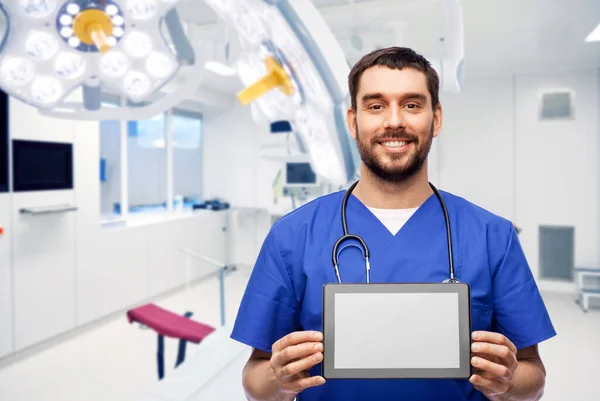 Médico feliz o enfermero varón mostrando tableta — Foto de Stock