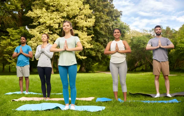 Groep mensen die yoga doen in het zomerpark — Stockfoto