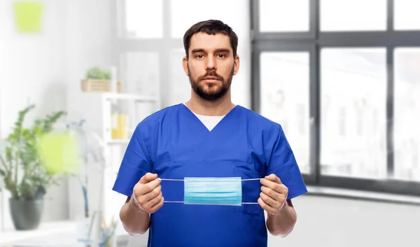 Médico masculino em uniforme azul com máscara — Fotografia de Stock