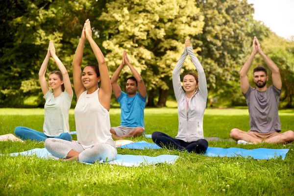 Group of people doing yoga at summer park — Stock Photo, Image