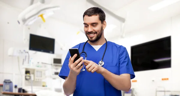 Mosolygós orvos vagy férfi ápoló okostelefon használatával — Stock Fotó