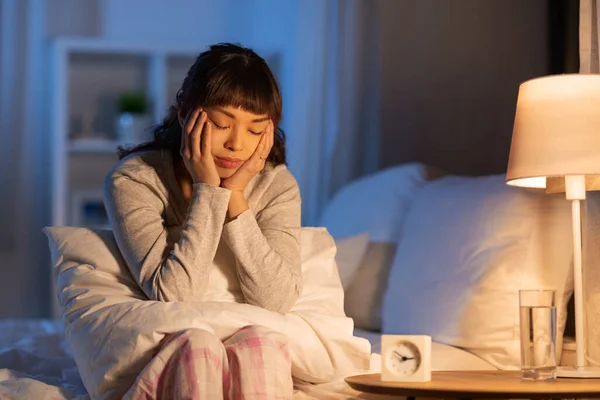 Estresado asiático mujer sentado en cama en la noche — Foto de Stock