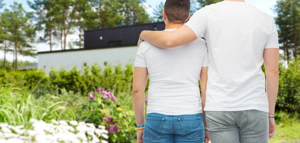 Masculino casal com gay orgulho pulseiras no jardim — Fotografia de Stock