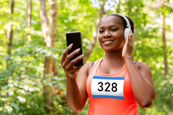 Coureur de marathon femelle avec casque et téléphone — Photo