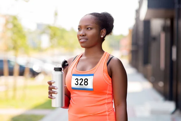 Marathon femme coureur eau potable de bouteille — Photo