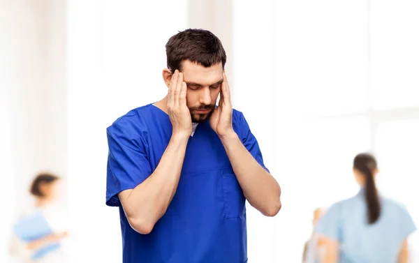 Стресова лікарка або медсестра чоловічої статі в синій формі — стокове фото