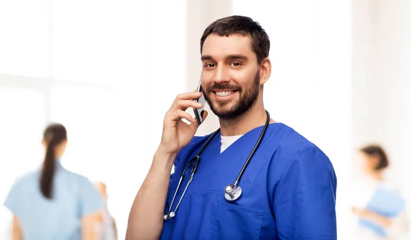 Sonriente médico o enfermero llamando en smartphone — Foto de Stock