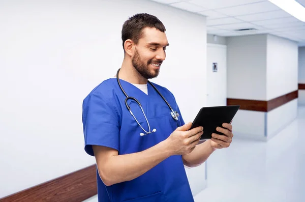 Médico sorridente ou enfermeiro masculino usando computador tablet — Fotografia de Stock