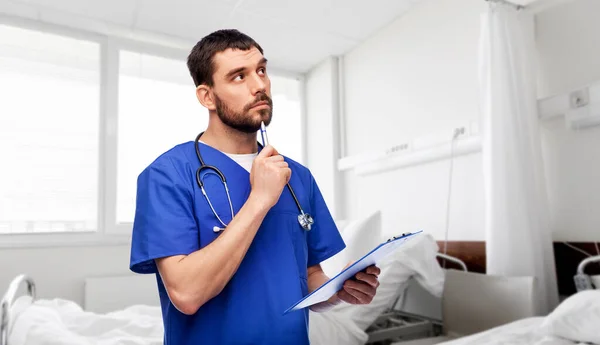 Doctor or male nurse with clipboard — Stock Photo, Image