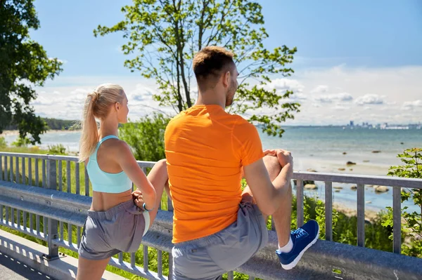 Young sporty couple stretching legs — Stock Photo, Image