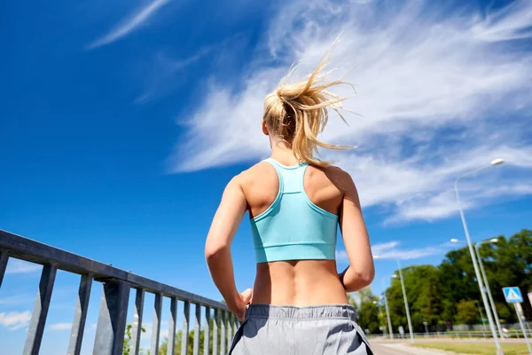 Sportovní mladá žena běží venku — Stock fotografie