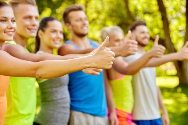 Gruppe fröhlicher sportlicher Freunde zeigt Daumen hoch — Stockfoto