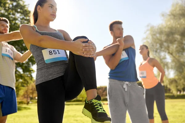 Glada människor tränar med tränare i parken — Stockfoto