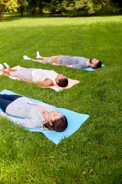 Grupo de personas haciendo yoga en el parque de verano —  Fotos de Stock