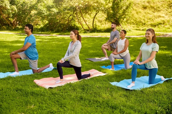 Groep mensen die yoga doen in het zomerpark — Stockfoto