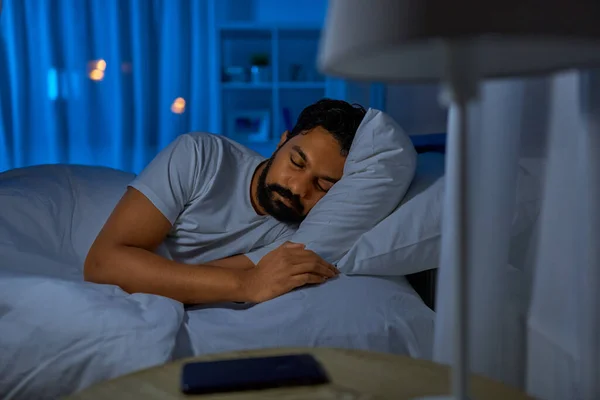 Hombre indio durmiendo en la cama en casa por la noche — Foto de Stock