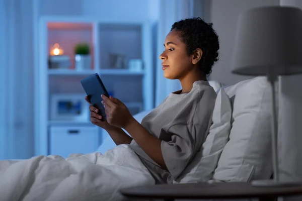 Frau mit Tablet-PC nachts zu Hause im Bett — Stockfoto