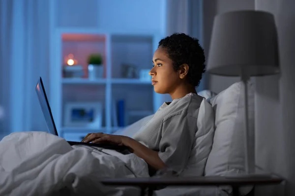 Frau mit Laptop nachts zu Hause im Bett — Stockfoto