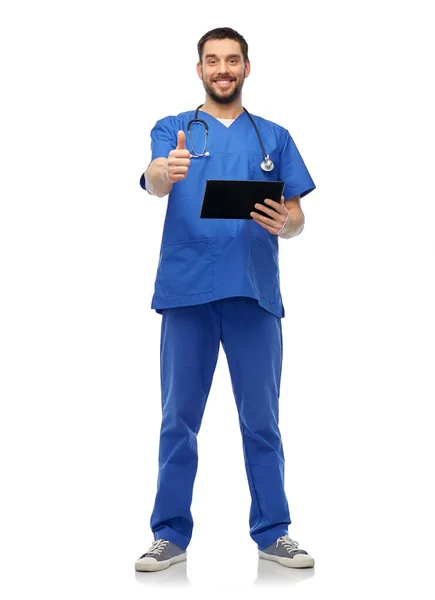 Счастливый врач мужчина с планшетным ПК показывая большие пальцы вверх — стоковое фото
