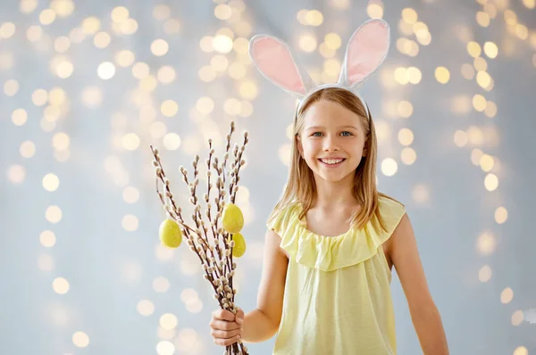 Menina sorridente com salgueiro decorado por ovos de Páscoa — Fotografia de Stock