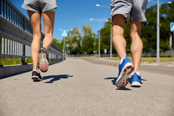 Fötter sportiga par som springer längs stadsvägen — Stockfoto