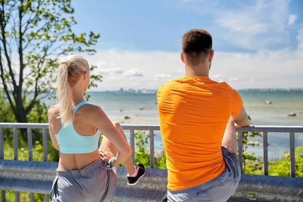 Joven deportivo pareja estiramiento piernas —  Fotos de Stock