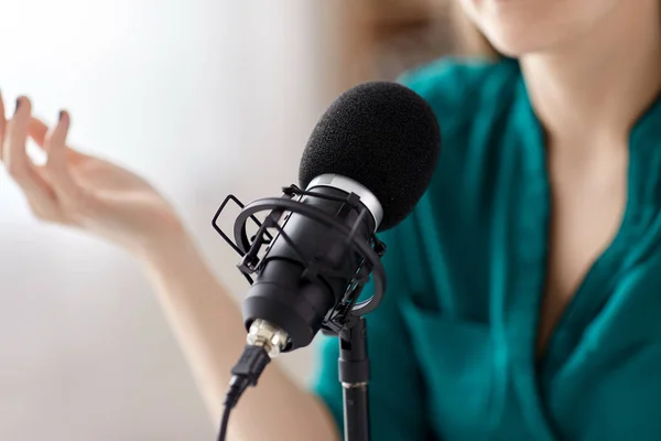 Женщина с микрофоном запись подкаста в студии — стоковое фото