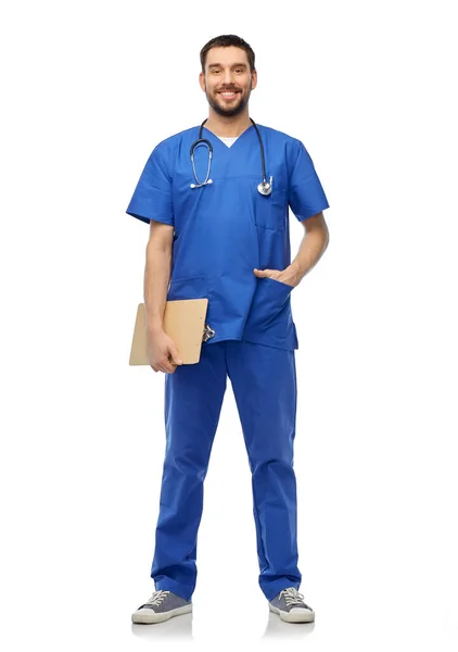 Médico sonriente en uniforme azul con portapapeles — Foto de Stock