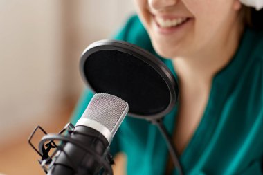 woman with microphone recording podcast at studio clipart