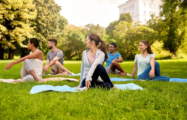 Grupo de personas haciendo yoga en el parque de verano — Foto de Stock