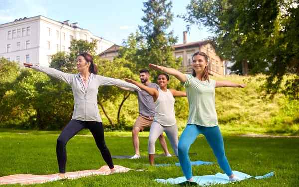 Groep mensen die yoga doen in het zomerpark — Stockfoto