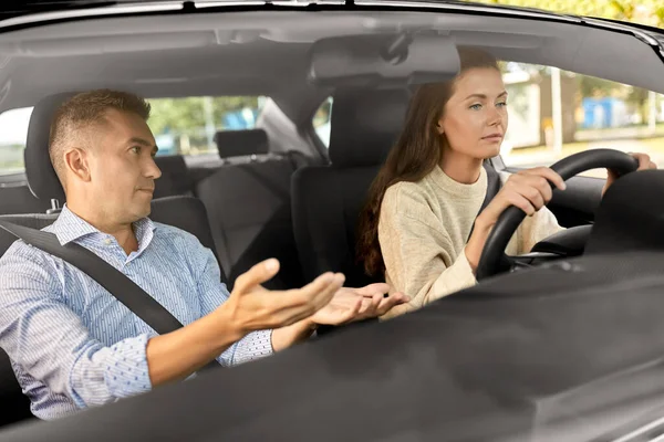 car driving school instructor teaching woman