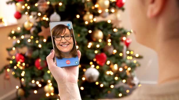 Frau mit Smartphone hat Videoanruf an Weihnachten — Stockvideo