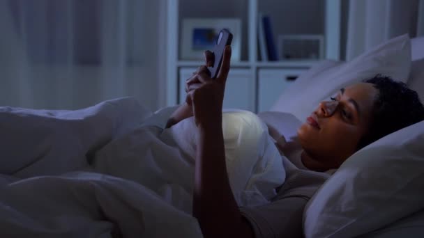 Žena s chytrým telefonem v posteli doma v noci — Stock video