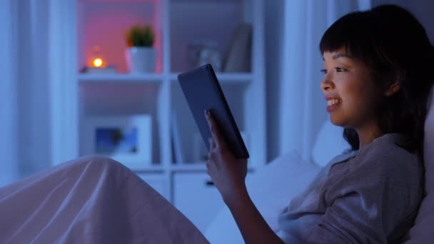 Žena s tabletou PC v posteli doma v noci — Stock video