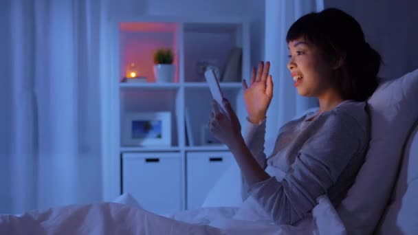 Žena s telefonem v posteli s videohovory v noci — Stock video